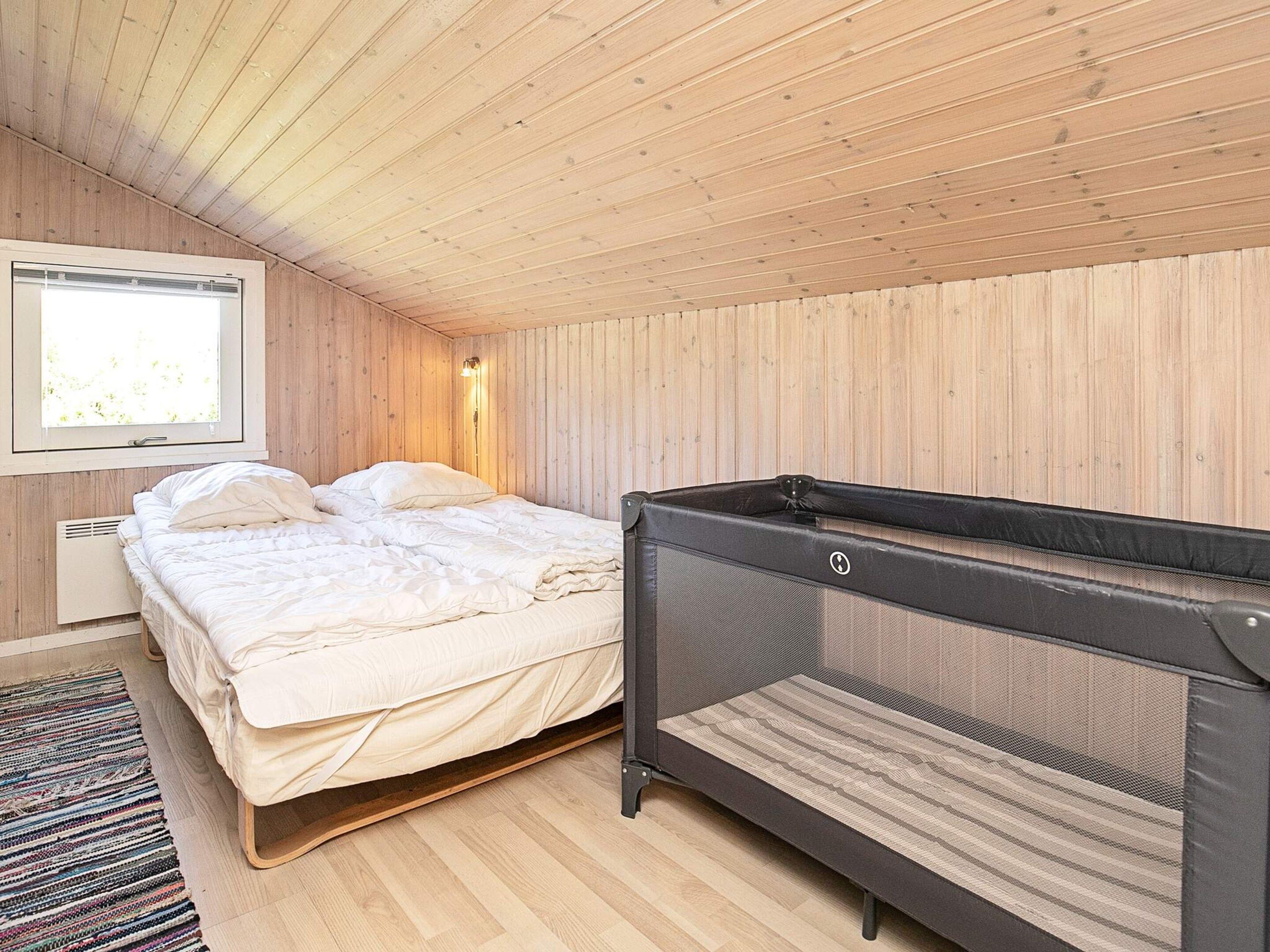 A room with a bed, a window, and a bunk bed.