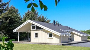 A single-story building with a gabled roof, a covered patio area, and a number '28' sign. - 4 Star Holiday Home in Hjorring (Hjørring)