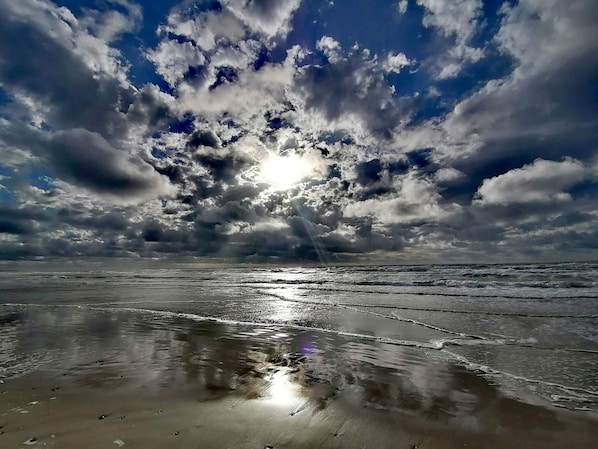 A beach with waves, a cloudy sky, and sunlight. - 4 Star Holiday Home in Lokken (Lokken)