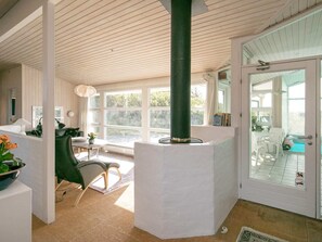 A room with a large window, a green pillar, and a door leading to an outdoor area. - 5 Star Holiday Home in Lokken (Lokken)