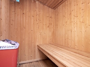 A sauna room with wooden walls and a bench. - 5 Star Holiday Home in Lokken (Lokken)