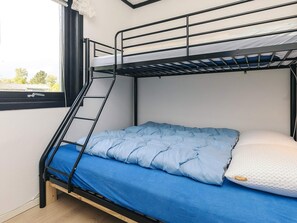 A bunk bed with a ladder, a blue mattress, and a white pillow. - 6 Person Holiday Home in Gedser (Gedser)