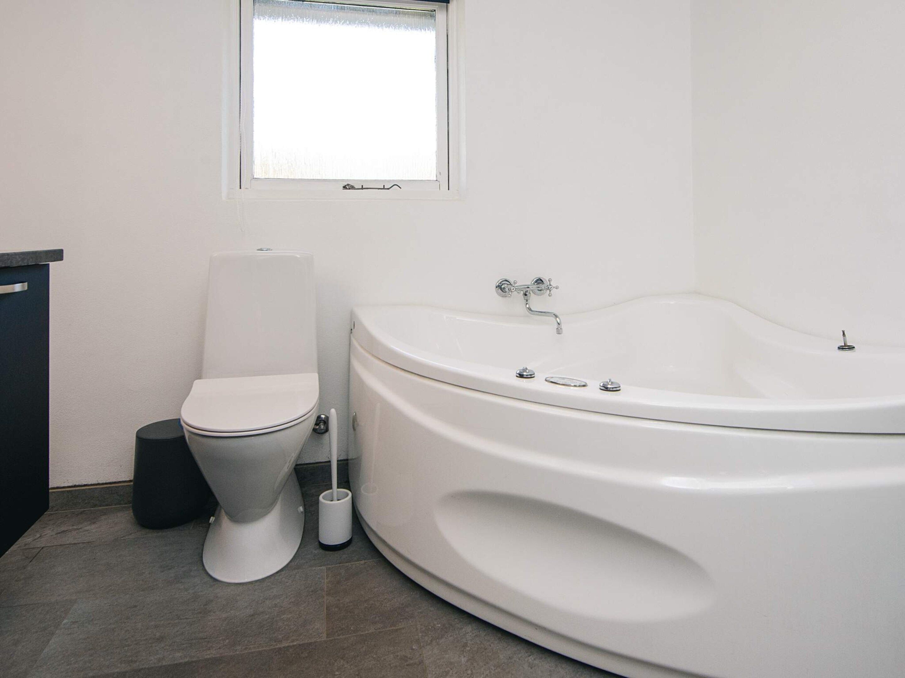Et moderne badeværelse med toilet, bidét og badekar.