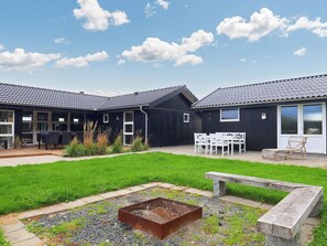 A modern building with a flat roof, large windows, and a well-maintained lawn.