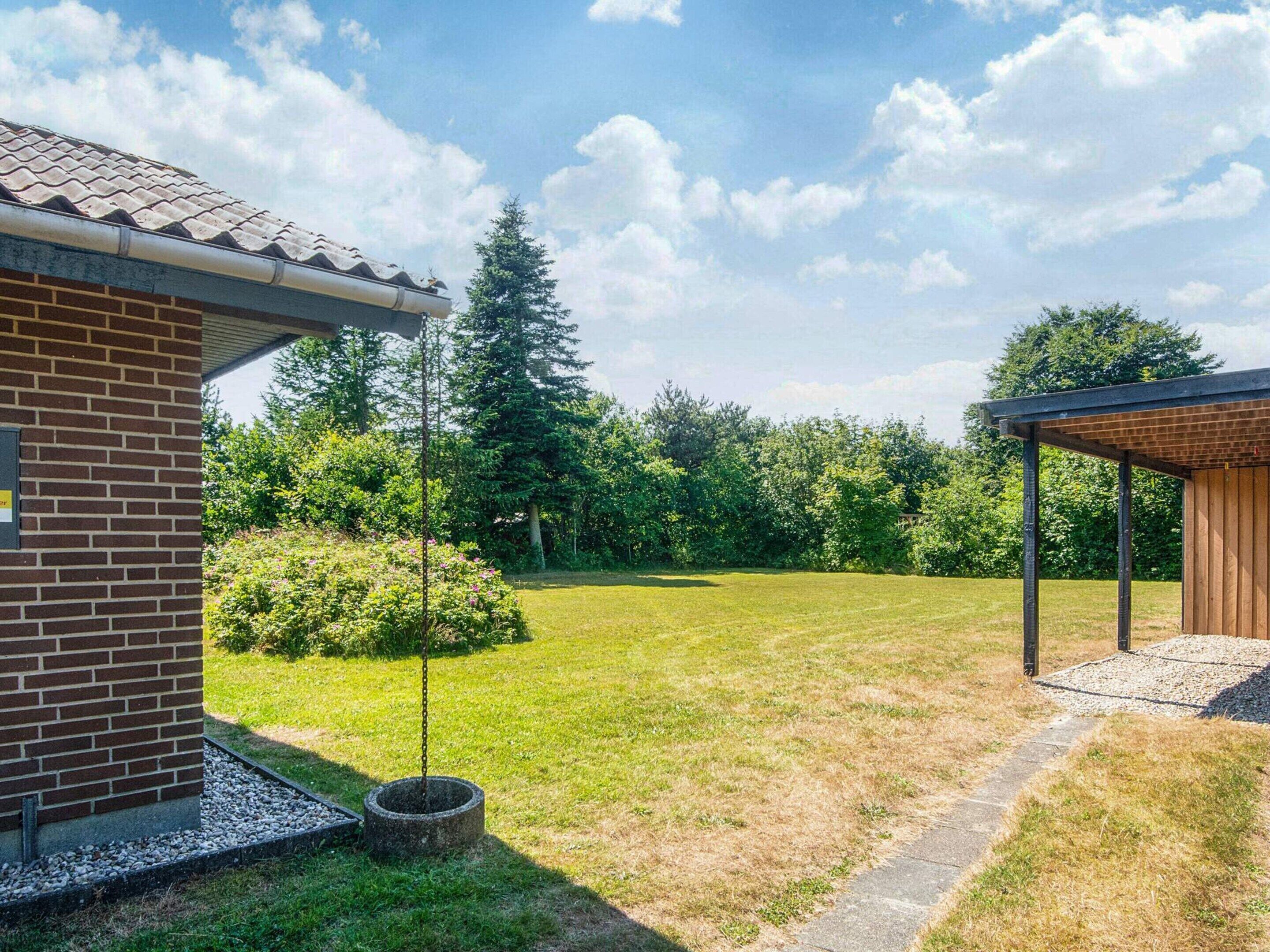 A brick building with a covered patio area and a well-maintained lawn.