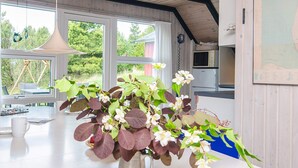 A kitchen with a white countertop, a metal pitcher with flowers, and a map on the wall. - 4 Star Holiday Home in Romo (Rømø)