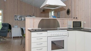 Et moderne køkken med indbygget ovn, mikroovn og stor komfur.