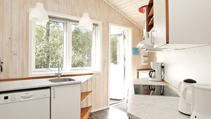 A modern kitchen with wooden walls, a dishwasher, a sink, and a coffee maker. - 6 Person Holiday Home in Albaek-by Traum (Aalbaek)