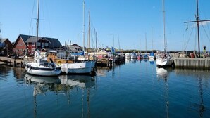 A marina with several sailboats docked, a wooden pier, and buildings in the background. - 6 Person Holiday Home in Albaek-by Traum (Aalbaek)