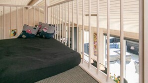 A bedroom with a bed, pillows, a window, and a balcony with outdoor furniture. - 4 Star Holiday Home in Blavand (Blavand)