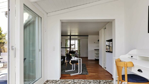 A modern interior with a stone-patterned floor, a wooden chair, and a white desk. - Stunning Holiday Home in Hovedstaden With Terrace (Gilleleje)