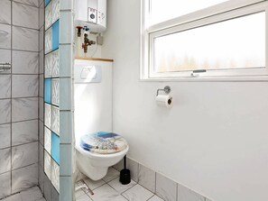 A bathroom with a toilet, a hand dryer, and a window. - Stunning Holiday Home in Hovedstaden With Terrace (Gilleleje)