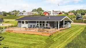 A single-story building with a covered patio area, a small deck, and a flagpole. - Holiday Home in Hejls (Hejls)