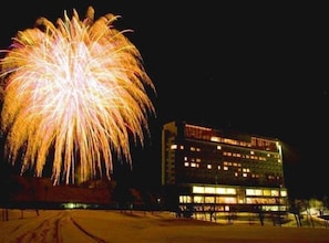 A building with multiple floors, a flat roof, and a large, illuminated sign on the front.