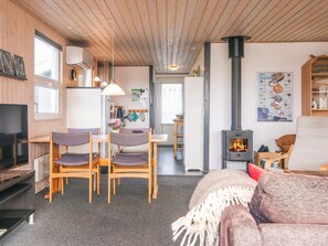 A cozy living area with a fireplace, wooden furniture, and a television.