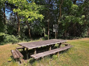 Et rustikt picnicbord med bænke i et skovområde.