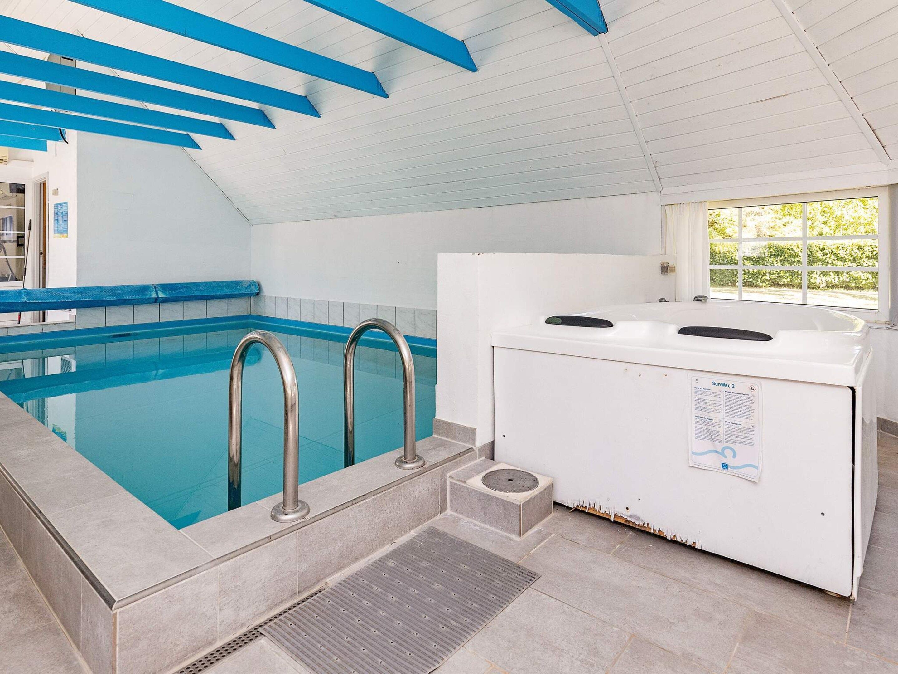 Ein Hallenbad mit blau gefliestem Boden, einer weißen Wand und einer blauen Decke.