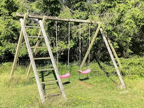 A wooden swing set with a ladder, surrounded by greenery. - 4 Star Holiday Home in Vaeggerlose (Vaeggerlose)