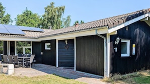 A modern house with a covered patio, solar panels, and a garage. - 4 Star Holiday Home in Vaeggerlose (Vaeggerlose)