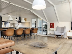 A modern interior with a dining area, kitchen, and seating space.