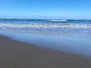 A beach with waves approaching the shore.