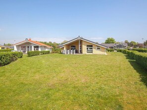 A row of single-story houses with a well-maintained lawn and hedges. - Holiday Home in GrÃ¶mmitz (Groemitz)