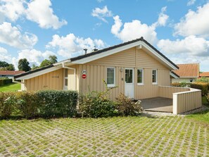 A single-story building with a beige exterior, a white door, and a small porch area. - Holiday Home in GrÃ¶mmitz (Groemitz)