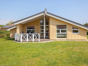 A single-story house with a deck, large windows, and a satellite dish. - Holiday Home in GrÃ¶mmitz (Groemitz)