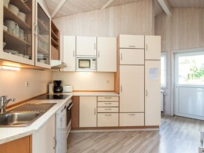 A compact kitchen with a microwave, coffee maker, and a sink. - Holiday Home in GrÃ¶mmitz (Groemitz)