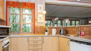 A kitchen with wooden cabinets, a microwave, a kettle, and a dishwasher. - 8 Person Holiday Home in Oksbol (Oksbol)