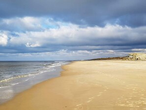 En strand med en klippe og en klar himmel.