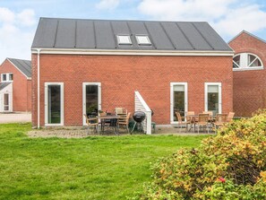A red brick building with a flat roof, two skylights, and a patio with outdoor furniture. - Elegant Holiday Home in RÃ¸mÃ¸ near Sea (Rømø)