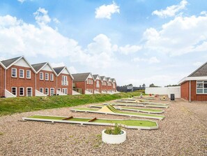 A row of brick houses with a gravel courtyard and a small garden area.