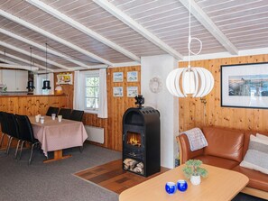 A cozy room with a fireplace, a dining area, and a seating area with a sofa and a coffee table.