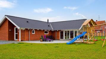A wooden building with a blue slide and a wooden playhouse.