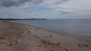 A beach with a sandy shore and calm water under a cloudy sky. - 5 Star Holiday Home in Sydals (Sydals)