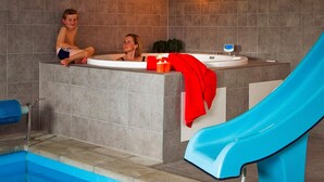 A swimming pool with a blue slide, a jacuzzi area, and a tiled wall. - 5 Star Holiday Home in Sydals (Sydals)