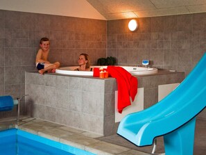 A swimming pool with a blue slide, a jacuzzi area, and a tiled wall. - 5 Star Holiday Home in Sydals (Sydals)