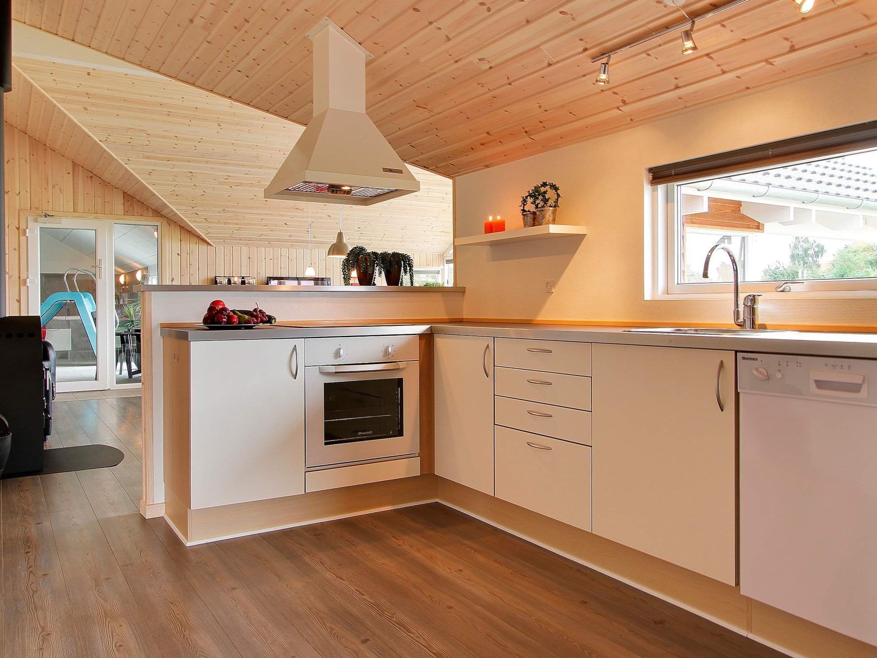 Une cuisine moderne avec des meubles en bois, un four encastré et une fenêtre offrant une belle vue.