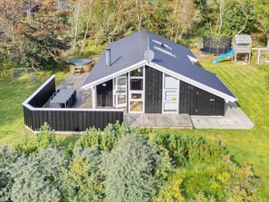 A modern house with a sloped roof, a deck, and a fenced yard. - 4 Star Holiday Home in Albaek (Aalbaek)