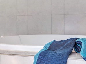 A bathtub with a towel draped over the side. - 5 Star Holiday Home in Idestrup (Idestrup)