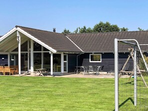 A house with a covered patio, a lawn, and a soccer goal. - 4 Star Holiday Home in Idestrup (Idestrup)