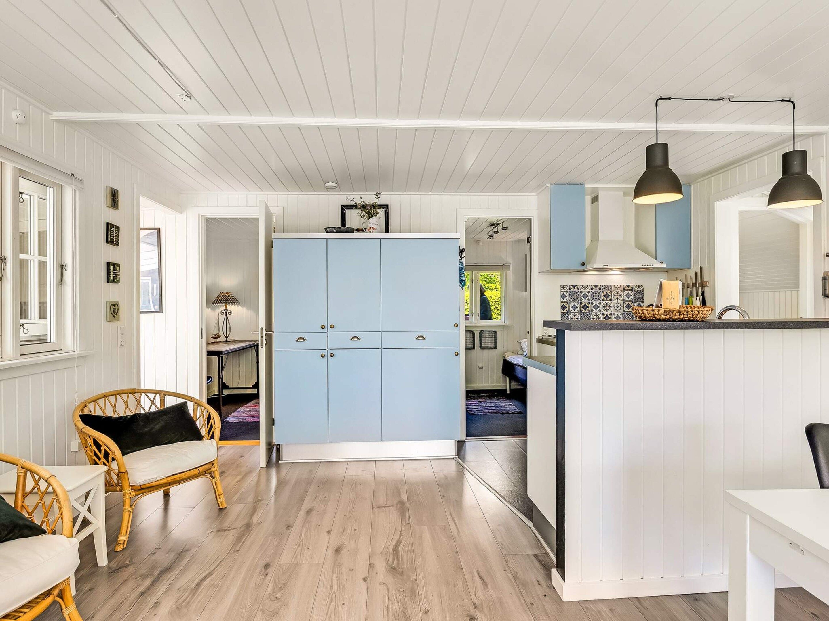 A modern kitchen with white cabinetry, a central island, and pendant lighting.