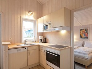 A compact kitchen with a dishwasher, stove, and microwave.