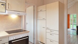 A kitchen with a built-in oven, a microwave, and a Siemens brand microwave oven. There are cabinets with silver handles and a glass door cabinet. - Holiday Home in GrÃ¶mmitz (Groemitz)