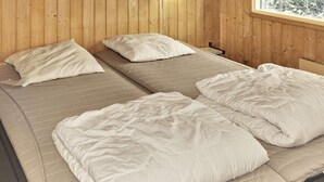 A room with wooden walls and a window. There are two beds with white bedding. - 8 Person Holiday Home in Vaeggerlose-by Traum (Vaeggerlose)