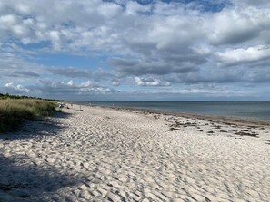 En sandstrand med klar himmel och en avlägsen horisont.