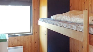 A bunk bed room with a window, a desk, and a power outlet.