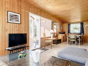 A wooden interior with a TV, dining table, chairs, and a sofa. - 6 Person Holiday Home in Vaeggerlose (Vaeggerlose)