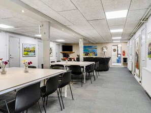 A conference room with a long table and chairs, a television, and artwork on the walls.